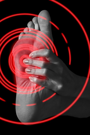 Pain in the female foot, monochrome image, pain area of red colorの写真素材
