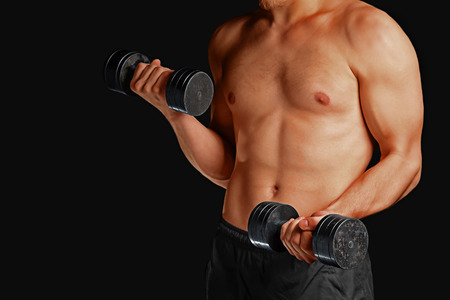 Unrecognizable muscular man exercises with metal dumbbellsの写真素材