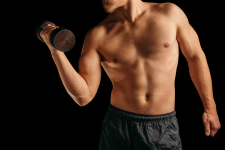 Unrecognizable muscular man makes exercises with dumbbellの写真素材