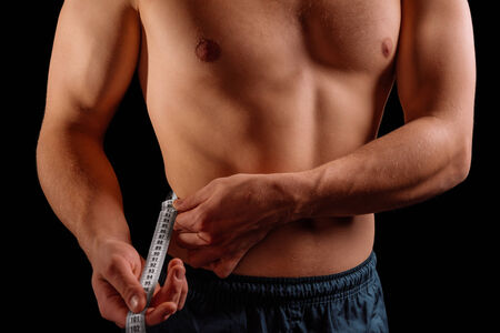 Sportsman is measuring waist with tape on a black backgroundの写真素材
