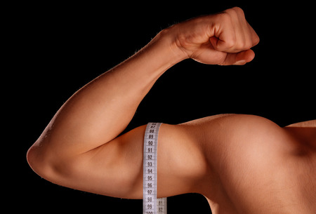 Male muscular hand with centimeter tapeの写真素材