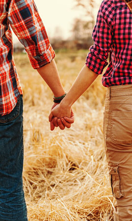 Young unrecognizable couple in love holding hands each other, serene sceneの写真素材