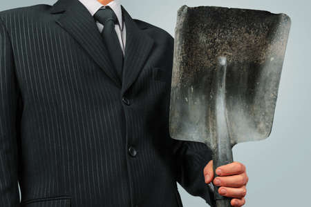 Unrecognizable businessman holds metal shovel, concept of business creationの写真素材
