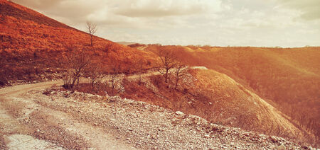Winding road in the mountains, autumn season. Image with sunlight effect