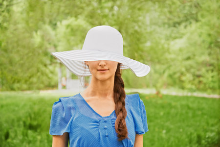 Young beautiful woman in a hat with a wide brim on natureのeditorial素材