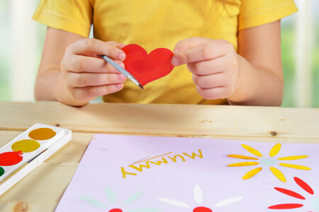 Child makes a greeting card for holiday happy mothers dayの写真素材