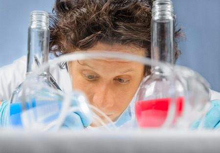 Scientist Dr. writes experience. In the foreground laboratory glasses