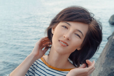 Happy young woman is smiling on the background of the seaの写真素材