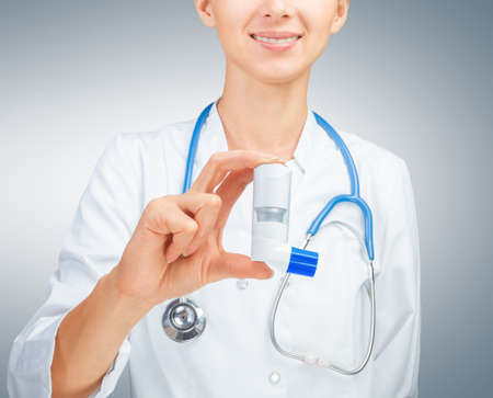 Female doctor holds inhaler for treatment  at asthma attackの写真素材