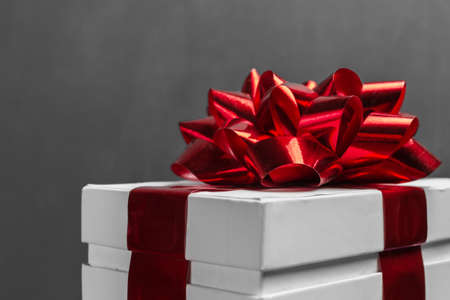 White gift box with red ribbon, close-upの写真素材