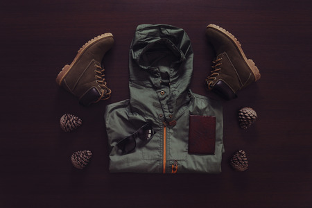 Set of clothing and accessories for traveler man on wooden background, top viewの写真素材