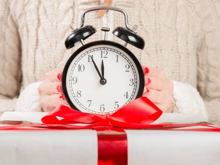 Woman with a clock waiting for the new year