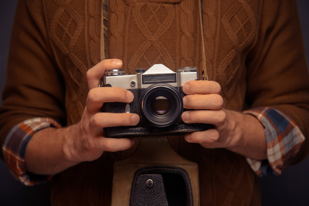 Unrecognizable man is holding an old photocamera