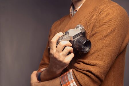Man in sweater is holding photo camera, space for textの写真素材