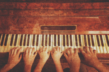 Family of three people is playing the piano, front view. Vintage imageの写真素材