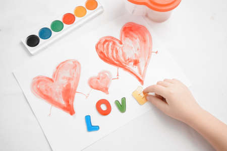 Child put on love letters to her drawing with hearts