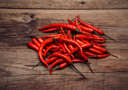 Many red chili peppers on a wooden の写真素材