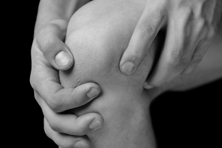 The man is touching the knee joint due to acute painの写真素材