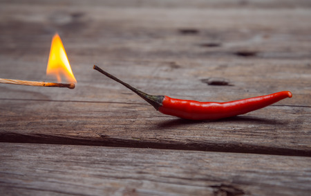 One red chili pepper and burning matchの写真素材