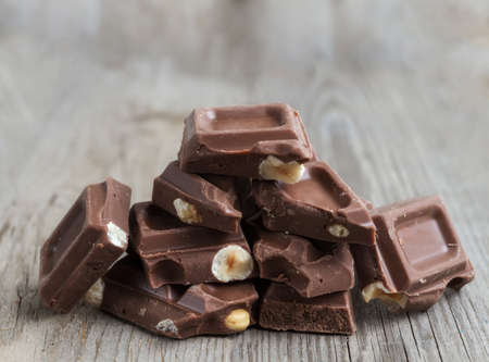 Chocolate with nuts lying on woodの写真素材
