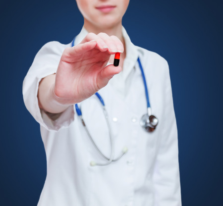 Doctor female opens the capsule on isolated / white の写真素材