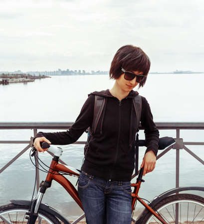 Young woman with bike on the background of the seaの写真素材