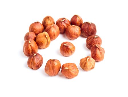 Hazelnuts in a circle isolated on white の写真素材