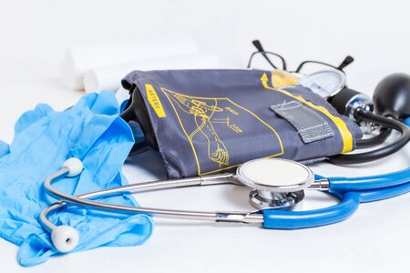 Close-up of a stethoscope and blood pressure monitor. on a white 