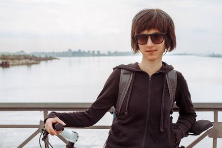 Young woman with bike on the background of the seaの写真素材