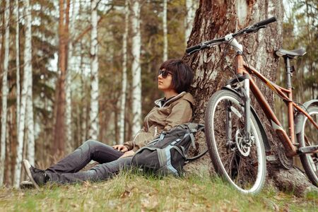 Cyclist enjoys nature near a big treeの写真素材