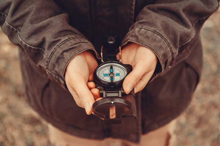 Hiker woman holding a compass on natureの写真素材