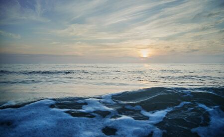 Seascape. Beautiful sunset over the sea. In the foreground wave with foam