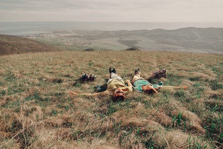 Couple in love lying on a mountain meadow above the sea in summerの写真素材