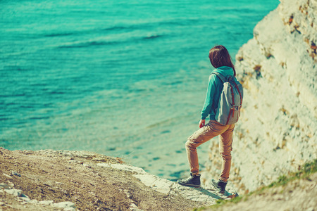 Traveler girl standing on coast and enjoying view of sea in summer.  の写真素材