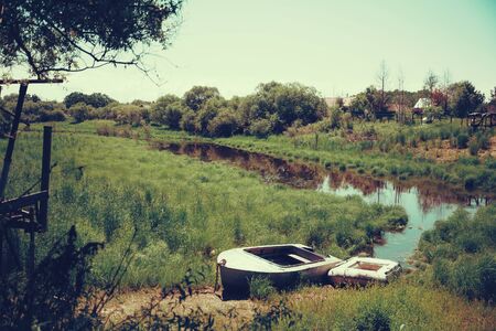 Fishing boats near river in the countryside in summer season, no peopleの写真素材
