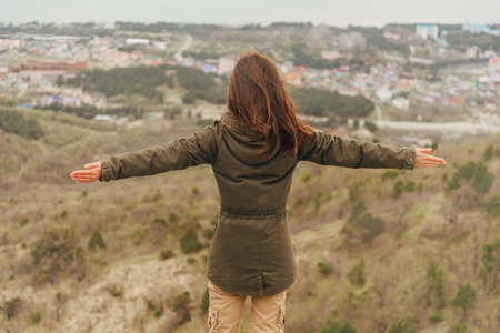 Happy hiker woman standing with raised arms and enjoying a nice dayの写真素材