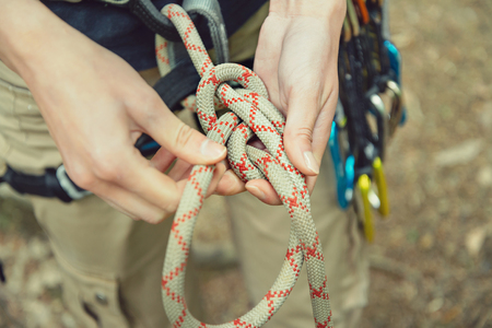 Climber woman doing a figure eight knot outdoor, view of hands, close-upの写真素材