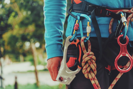 Rock climber wearing safety harness and climbing equipment outdoor, close-up imageの写真素材