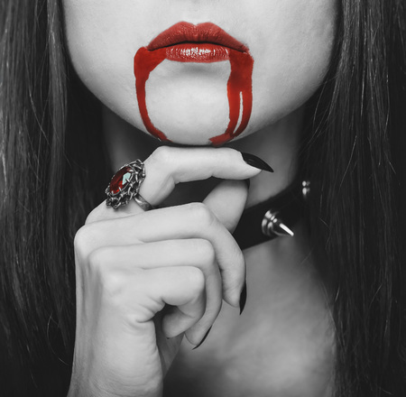 Beautiful vampire woman, red lips in blood. Monochrome image. Halloween or horror themeの写真素材
