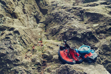 Climbing shoes and chalk bag with magnesium powder on stone rock outdoorの写真素材