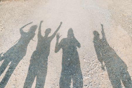Shadows of happy people at sunny day, group of friendsの写真素材