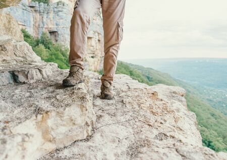 Hiker young woman walking on stone surface outdoor, view of legsの写真素材
