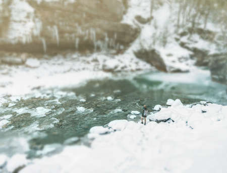Traveler woman walking along the river bank in winter, image with tilt-shift effect.の写真素材