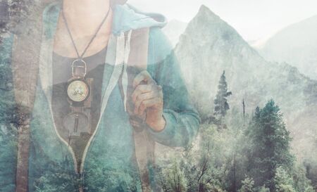 Double exposure image of female explorer with compass and mountain.の写真素材