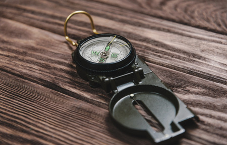 Hiking compass on a wooden background.の写真素材