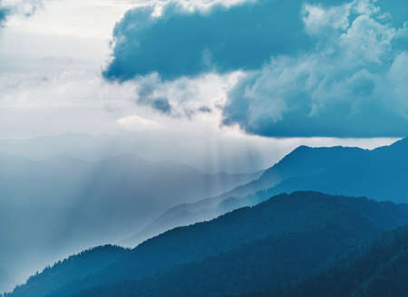 Mist over blue mountains in cloudy weather.