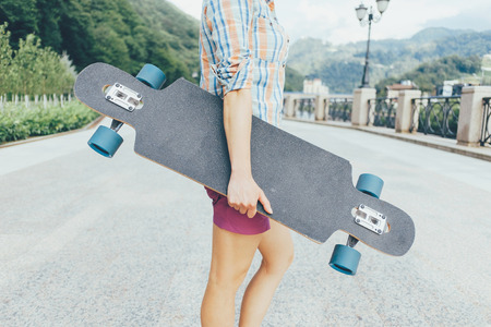 Unrecognizable teenager standing with longboard outdoor.の写真素材