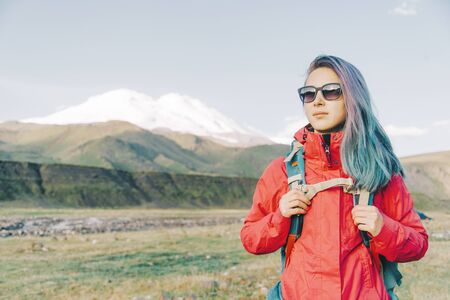Beautiful hiker young woman standing on background of mountain Elbrus.