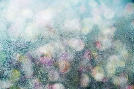 Background of water drops on glass on background of defocused city lights.の写真素材