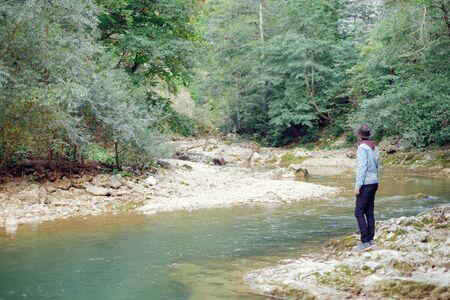 Explorer young man standing on the river bank and enjoying view of nature.の写真素材